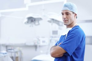 Male surgeon in scrubs stands in a dental operating room
